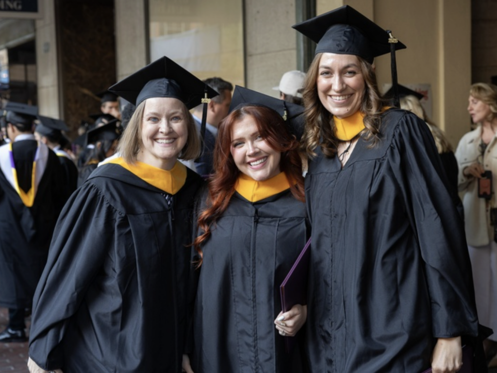 Three graduates pose for a photo