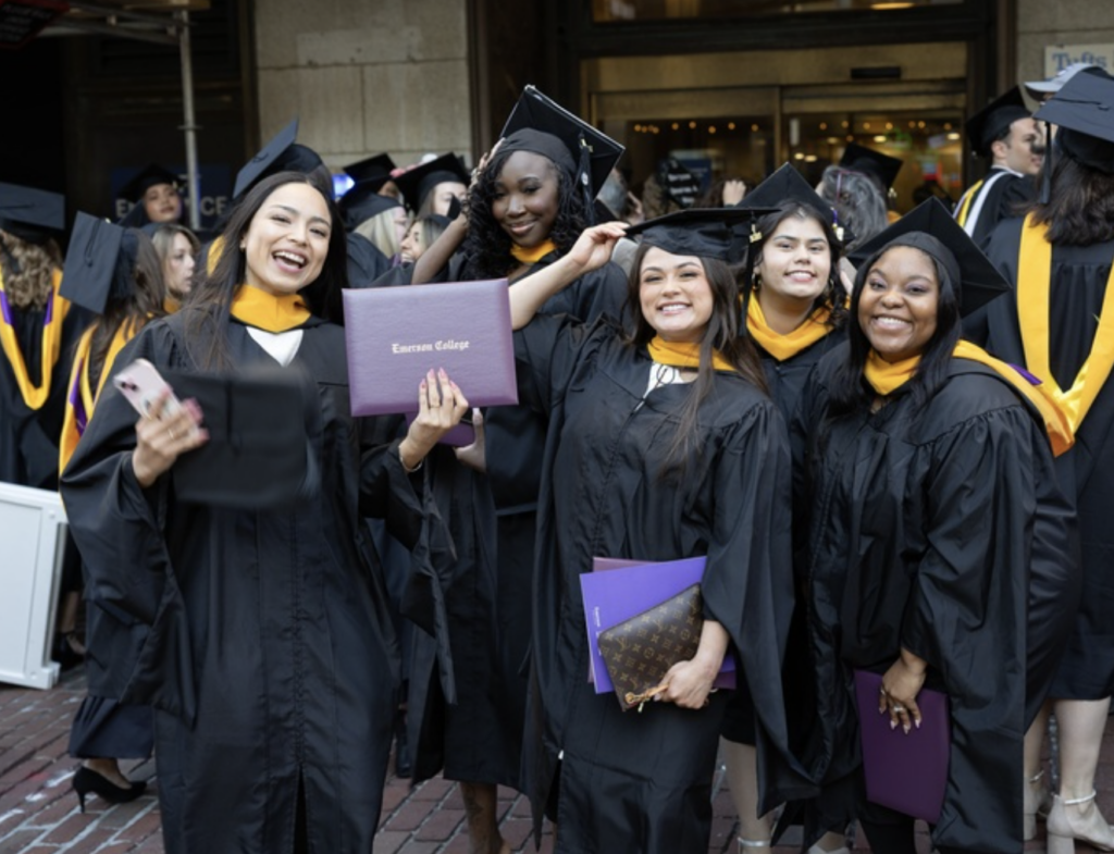 Several graduates pose for a photo outside