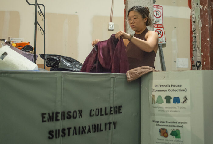 Sophie Lam sorts through donated items with a bin in front of her