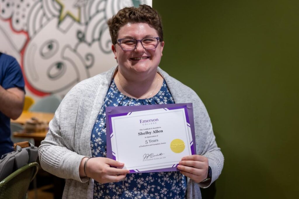 Shelby Allen holds up her certificate