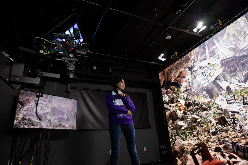woman looks at images on huge screen