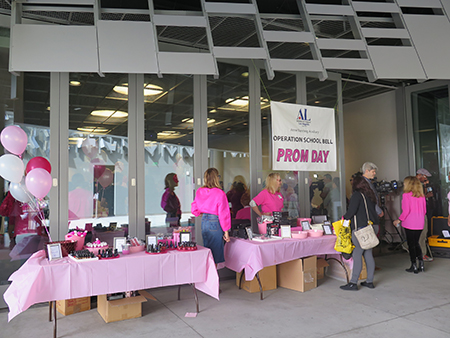 Volunteers at Operation School Bell Prom Day wear pink as they help high school girls pick out prom dresses and accessories.
