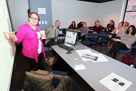 Headshot of Kat Grosso talking with a room of people